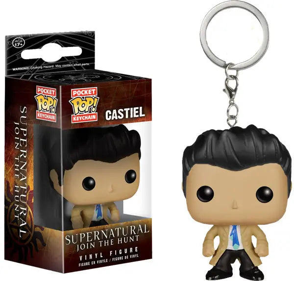 Close up of a keychain in the shape of the angel Castiel, wearing black pants and a tan raincoat. His features are cartoonish, with an extra large head. Next to the keychain is a brown box containing the same keychain. At the bottom of the box is white text saying "Supernatural, Join the Hunt. Vinyl figure."