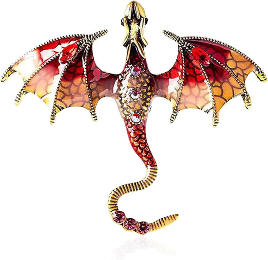 Close up view of a dragon-shaped brooch against a white background. The dragon is red with gold accents, and has red rhinestones inset in its tail and abdomen. The dragon's wings are spread out to the side, and its head is pointed straight out.