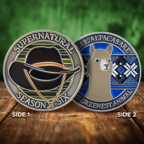 A brass coin charm with "Supernatural season six", a cowboy hat against a multicolor background on one side and "Well, alpacas are the greenest animal" with an alpaca over a blue, black and white patterned background on the other