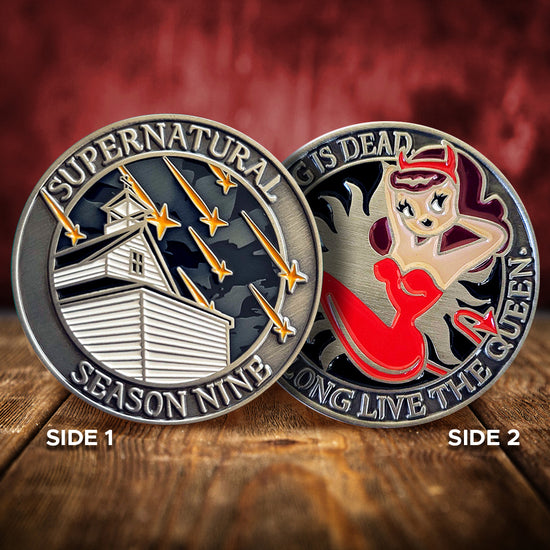 A brass coin charm with "Supernatural season nine", a church with falling stars on one side, and "The king is dead, long live the queen.", and a woman in a red jumpsuit with devil horns and a devil tail  with an anti-possession symbol background on the other