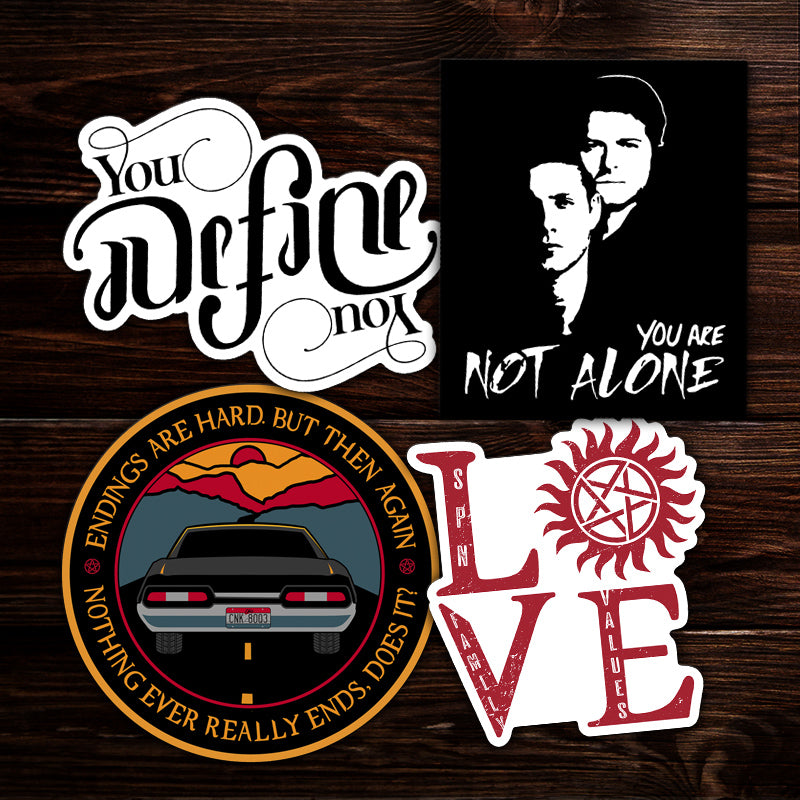A collection of vinyl stickers themed around the series Supernatural. The stickers are on a wooden background.