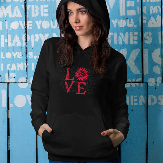 A female model wearing a black hoodie sweatshirt with red lettering that stacks LOVE - the "o" is the anti-possession symbol.
