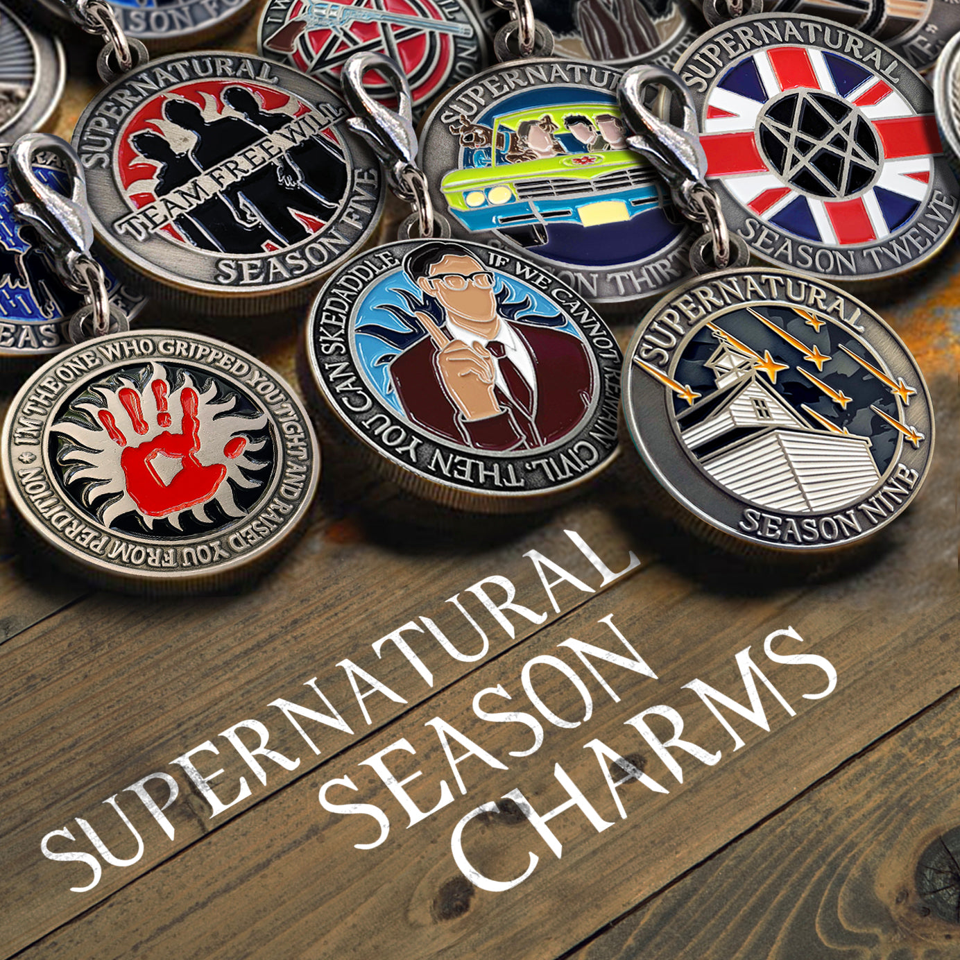 A stack of Supernatural challenge coin charms splayed out on a rustic wooden table.