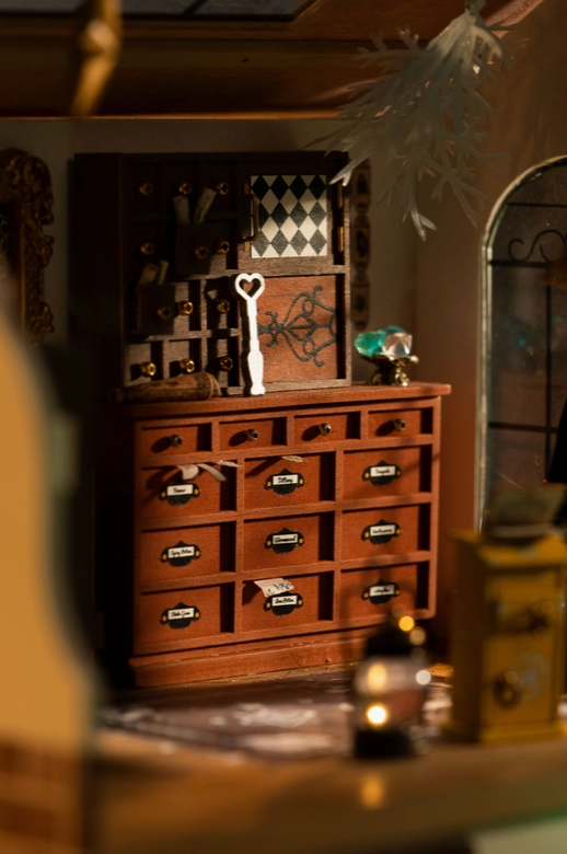 A close up of a wooden hutch, with tiny labels on each drawer.