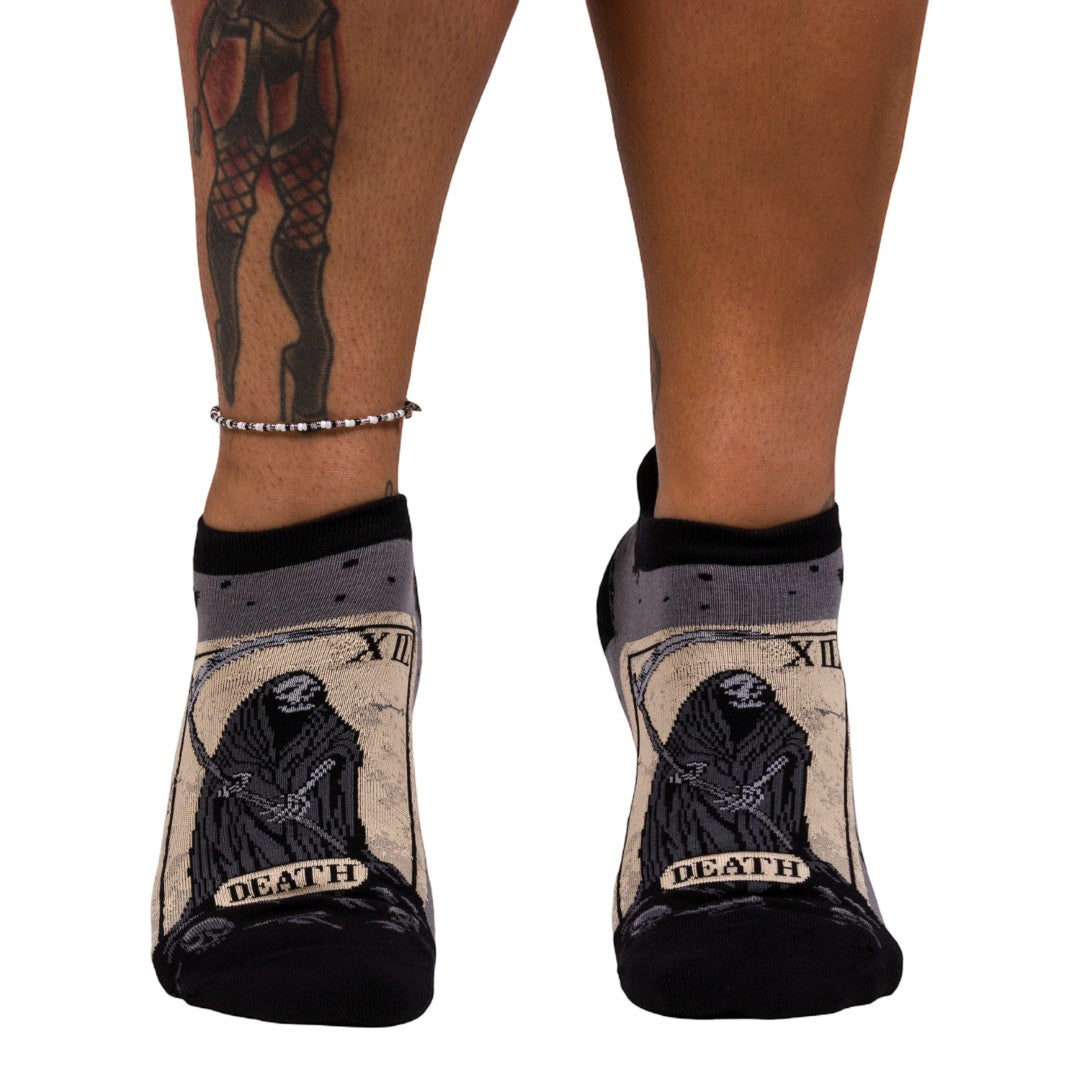 Socks with 'Death' tarot card design worn by a person on a white background