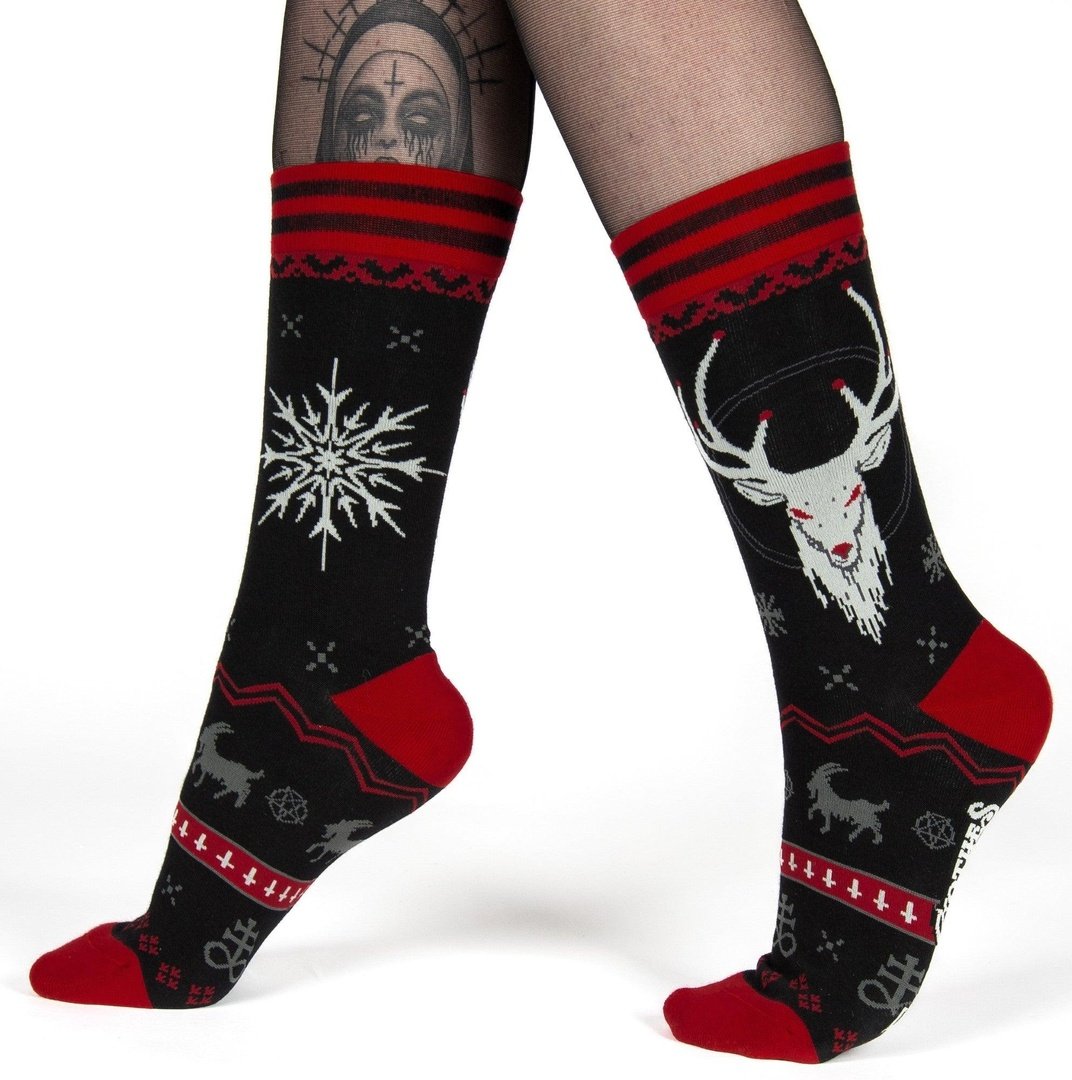 Black socks with red and white patterns worn by a person on a white background