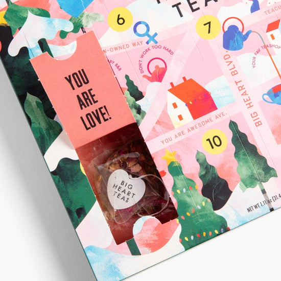 Close-up of an open slot on the advent calendar, with a bag of tea inside. The open tab has black text saying you are love!