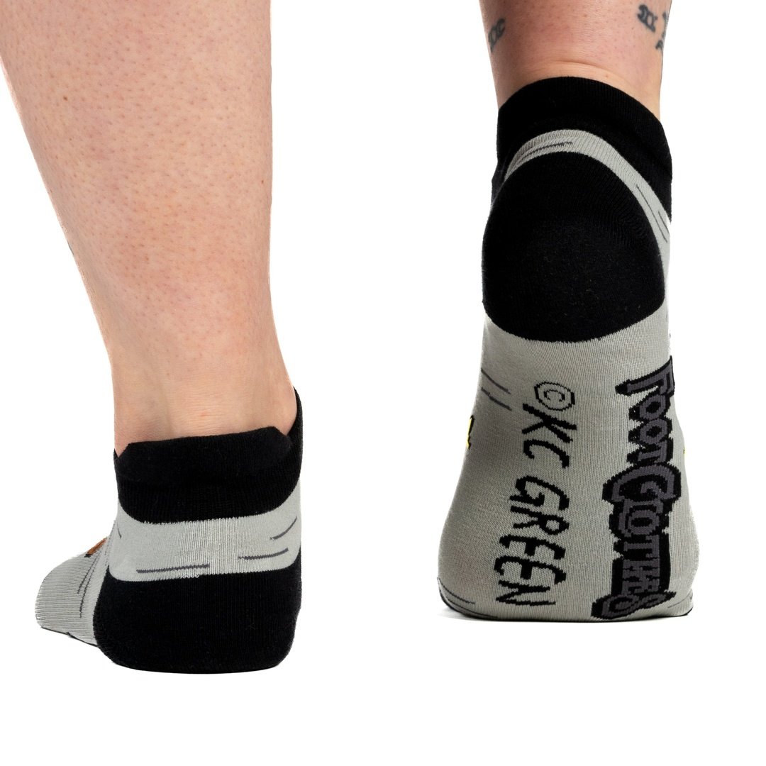 Person wearing black and gray socks with 'KC Green' branding on a white background