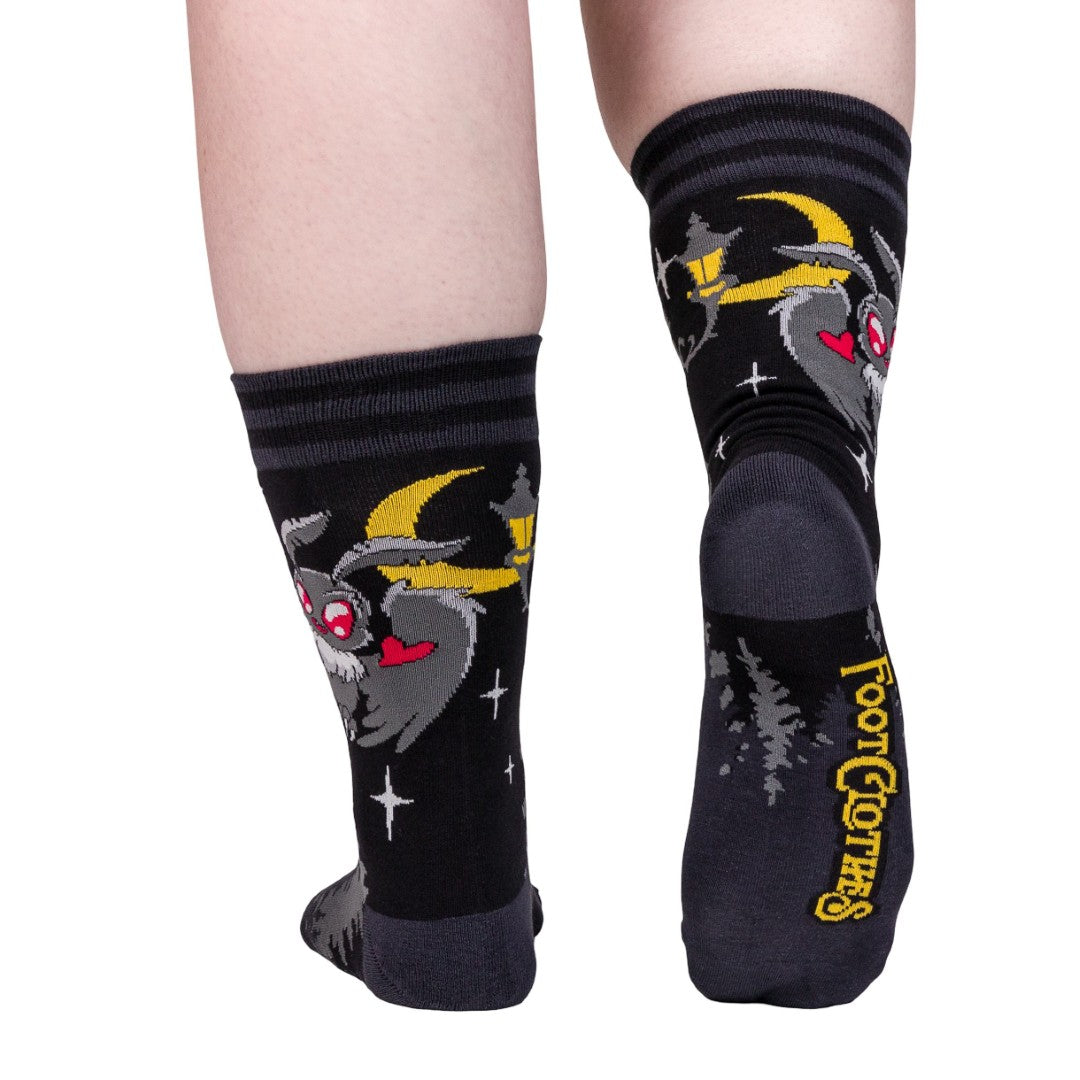 Black socks with cartoon character design worn by a person on a white background