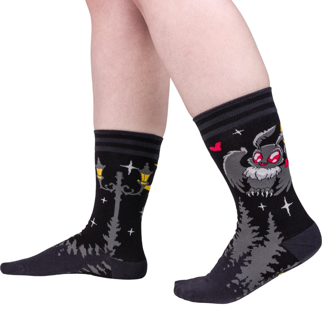 Black socks with cartoon character design worn by a person on a white background