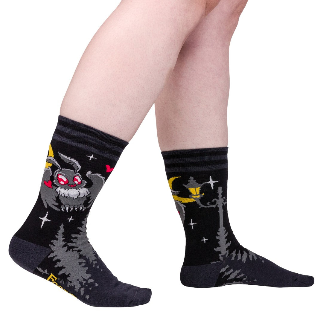 Black socks with cartoon character design worn by a person on a white background