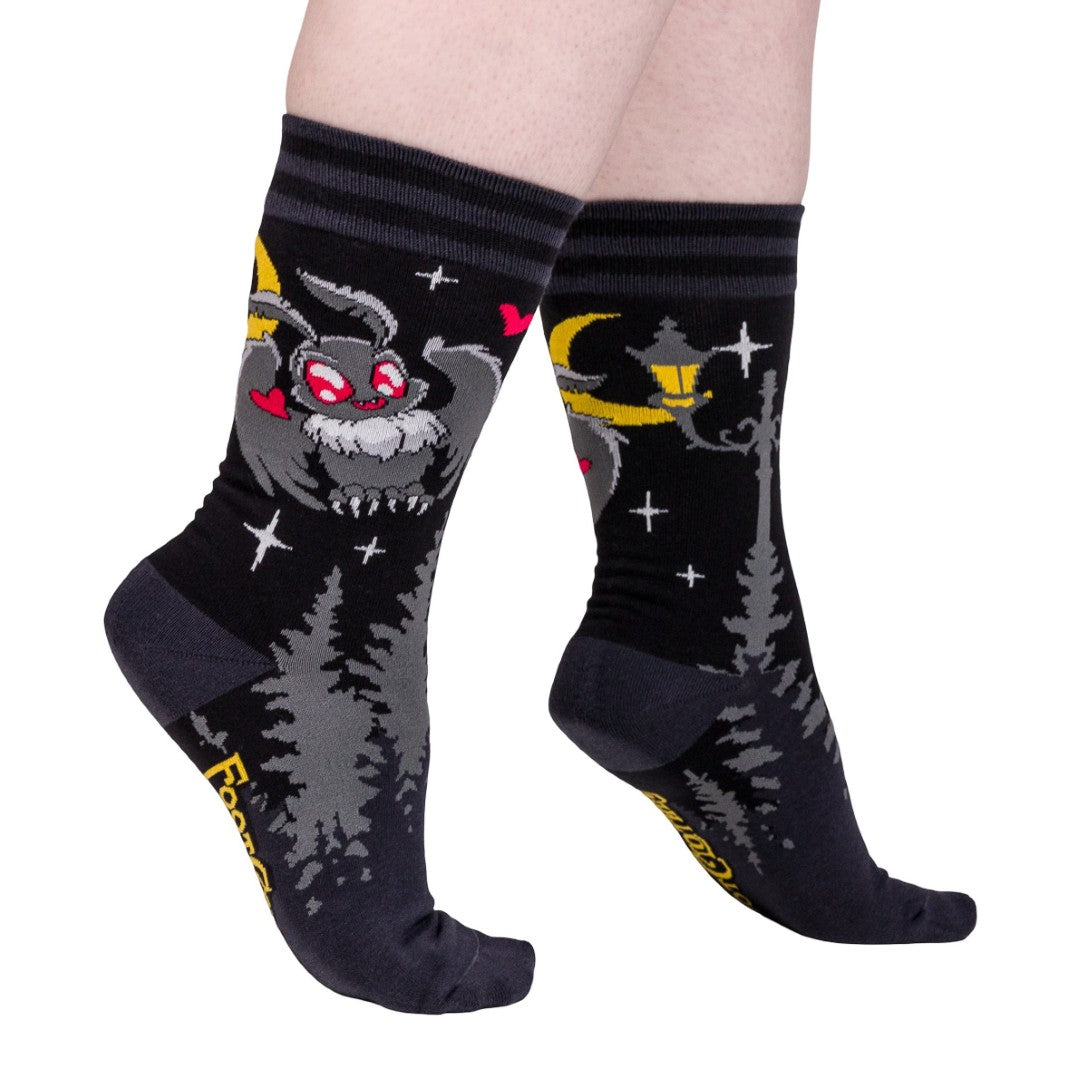 Black socks with cartoon character design worn by a person on a white background