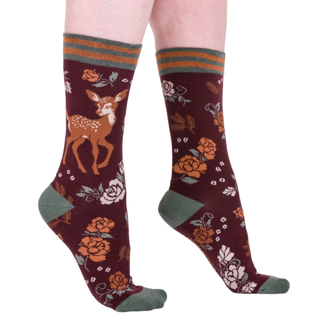 Maroon socks with deer and floral patterns on a white background