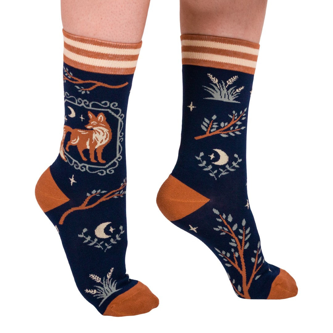 Navy blue socks with orange and white patterns featuring a fox and moon design on a white background.