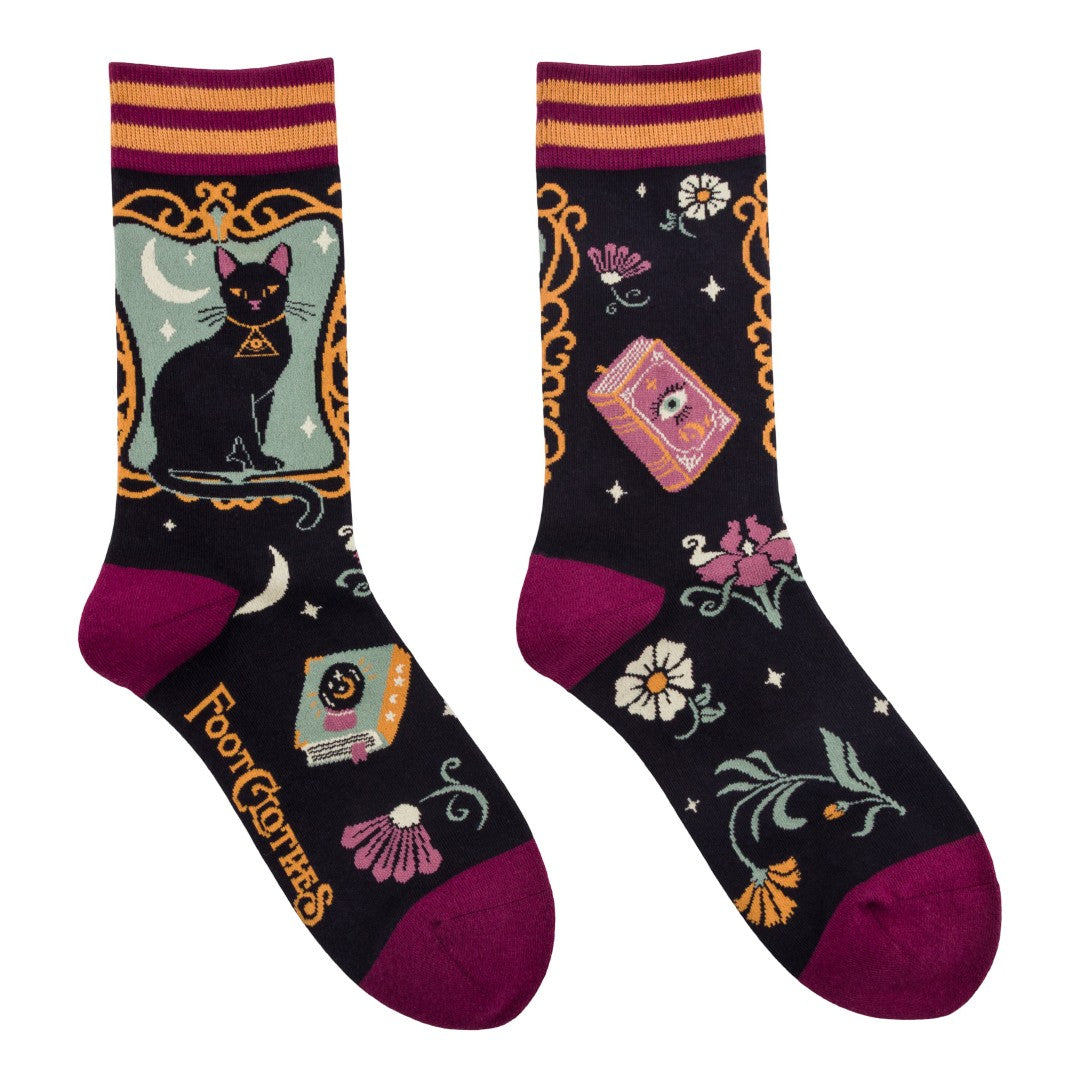 Decorative socks with black cat, tarot cards, and floral designs on a white background
