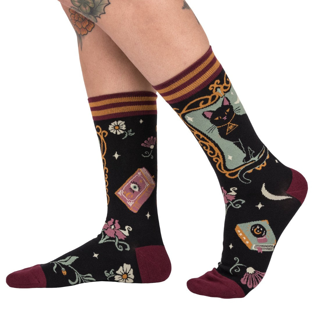 Decorative socks with cat and book design on a white background