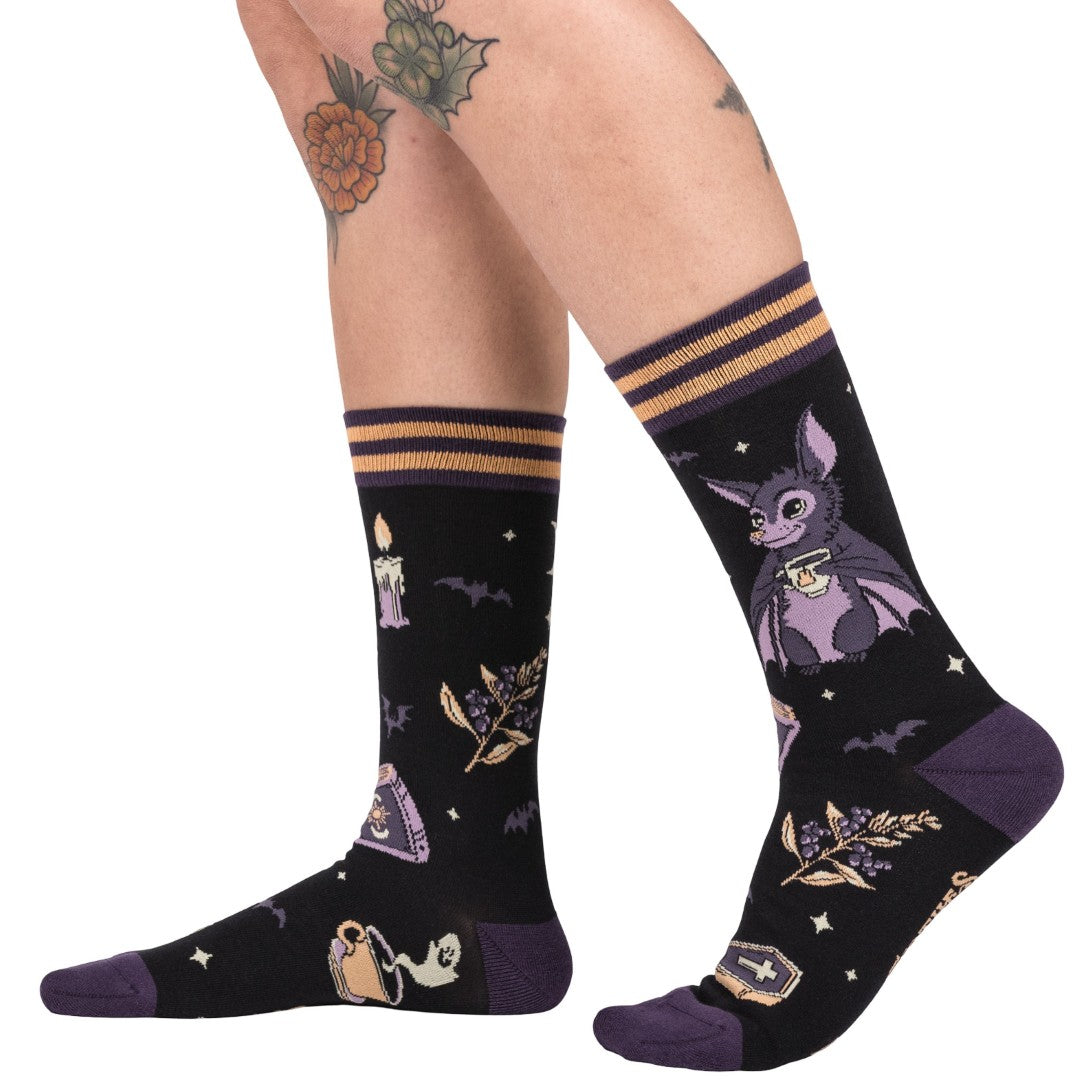 Black socks with purple accents featuring a bat design and Halloween-themed illustrations on a white background.