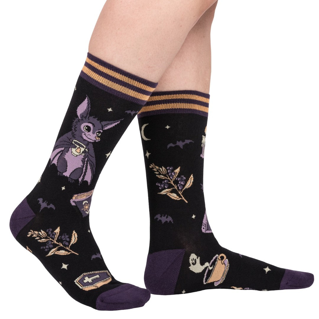 Black socks with purple bat and owl designs on a white background