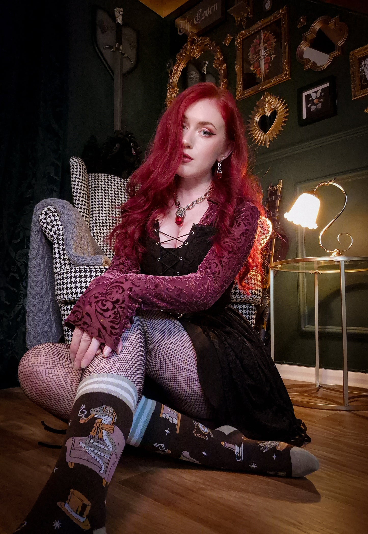 Woman with red hair sitting on a chair in a stylishly decorated room.