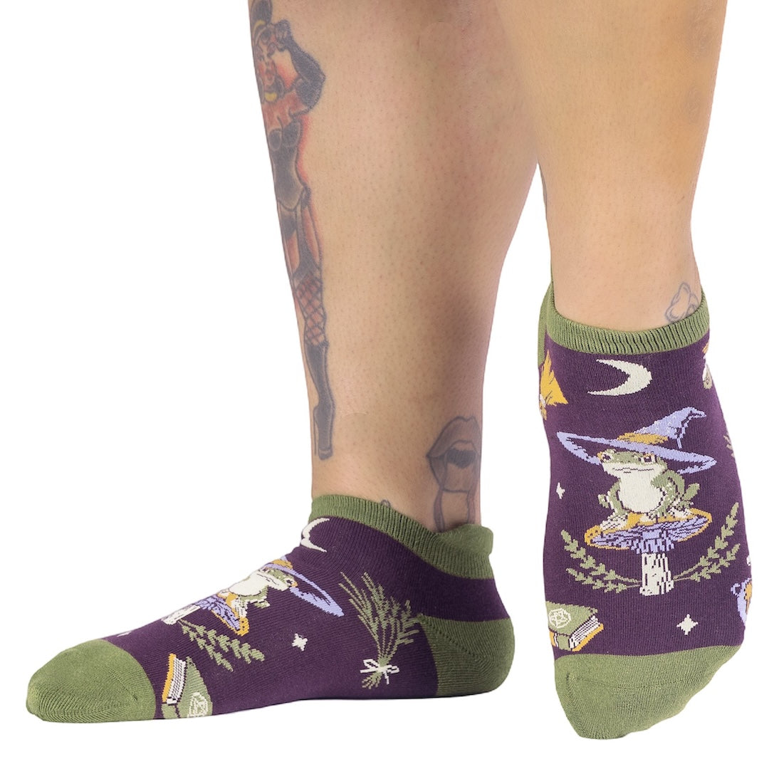 Purple socks with green accents worn by a person on a white background