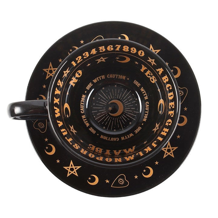 Black teacup and saucer set with gold symbols and text on a white background