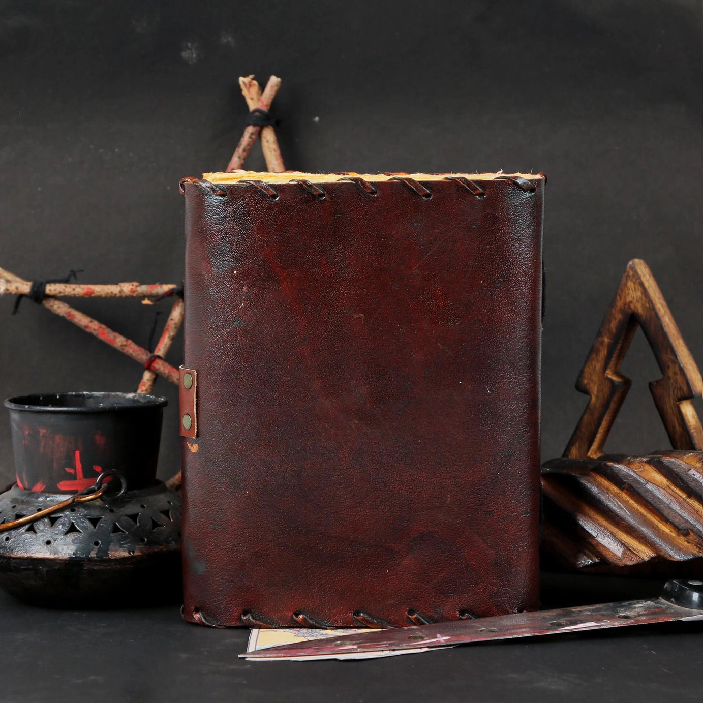 Brown leather journal with rustic elements on a dark background