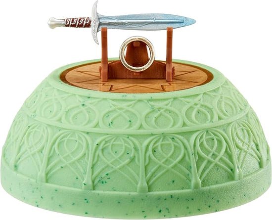A round, green half-sphere base with intricate carvings around the ides. At the top is a miniature wood-like stand holding the short sword "Sting" and the One Ring from The Lord Of The Rings.