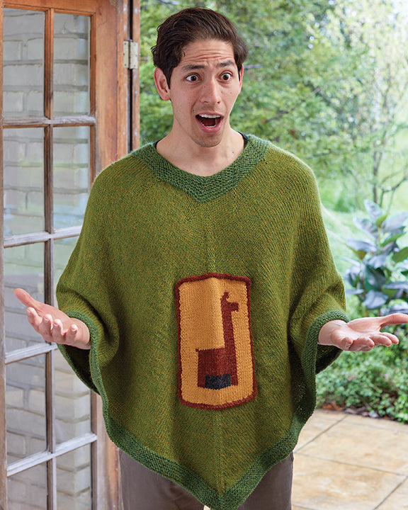 Man wearing a green poncho with a colorful emblem, standing outdoors.