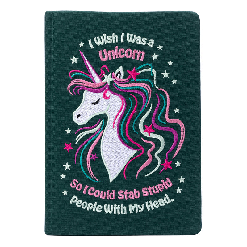 Notebook with unicorn illustration and humorous text on a dark green background