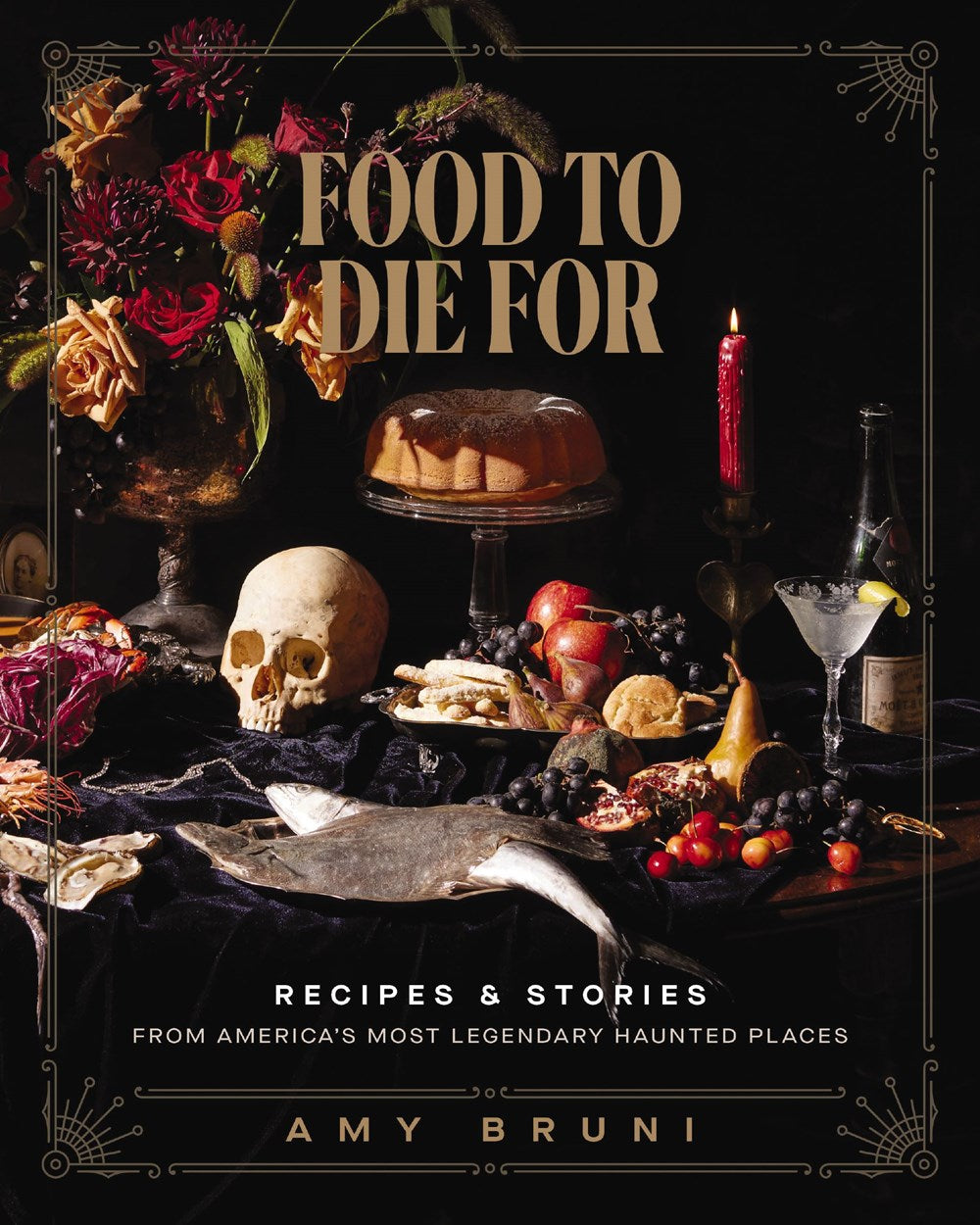 An image of a black book. On the front cover of the book is a collection of berries, candles, cakes, and flowers, against a black background. Gold text at the top says "Food to die for." At the bottom is white text saying "recipes & stories from america's most legendary haunted places." Next to the book is a human skull. 