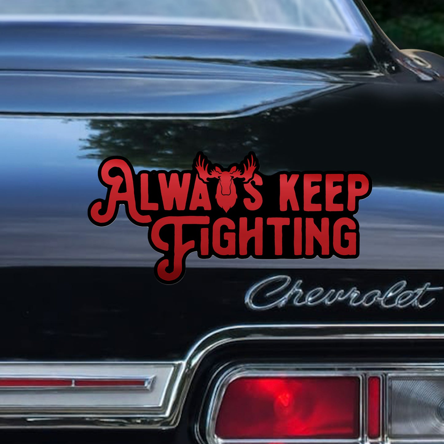 Black Chevrolet car with 'Always Keep Fighting' decal on the trunk