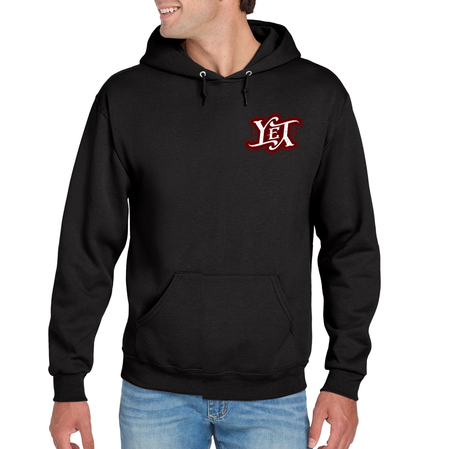 A male model wearing a black hooded pullover sweatshirt. On the left side are the letters YET in white, outlined in red. The letters are designed to spell the word "yet" right side up and upside down. 