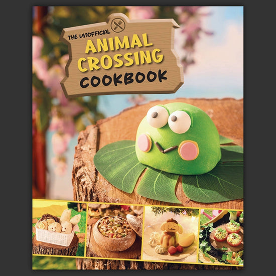 A hardcover cookbook featuring recipes inspired by the game Animal Crossing. At the top is a wooden sign with text saying "the unofficial animal crossing cookbook."