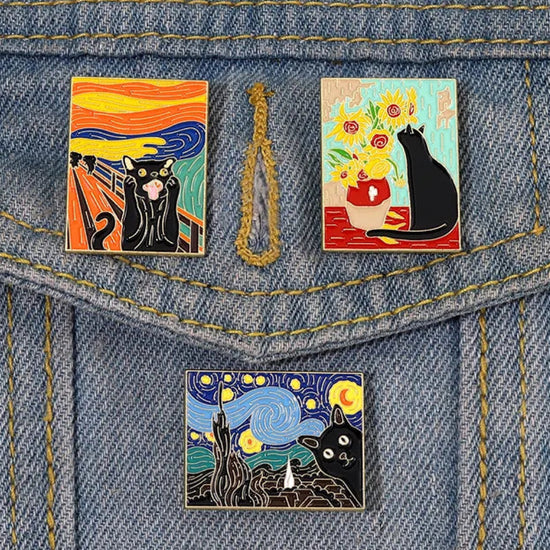 Three enamel pins attached to a blue denim jacket pocket. Each pin depicts a different classis painting, with a black cat inserted into the image.