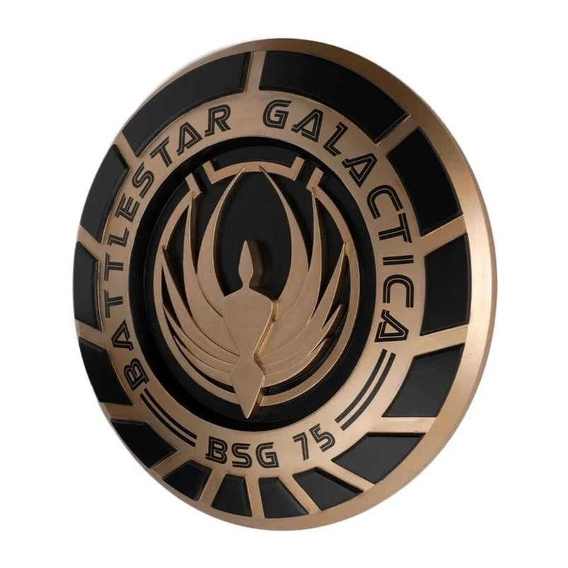 A bronze and black, round plaque, bearing the seal of the Battlestar Galactica.