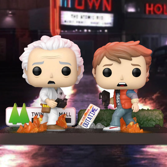 A pair of bobblehead figures depicting Doc Brown and Marty McFly from Back to the Future. In the background is a movie theater