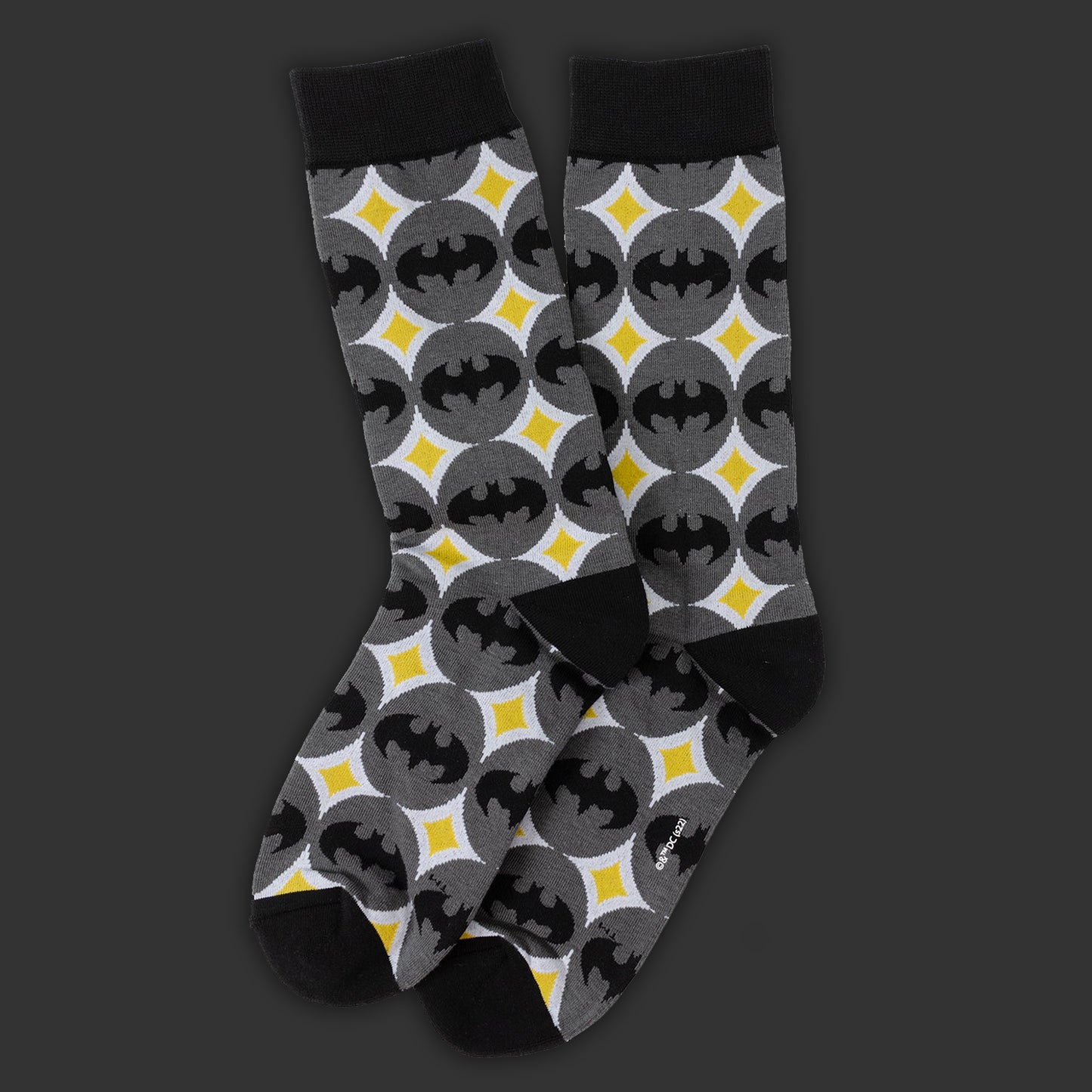 Pair of socks with Batman logo pattern on a dark background