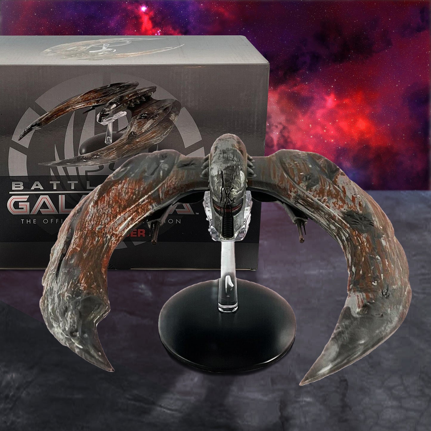Model spaceship on a stand with 'Battlestar Galactica' branding in the background