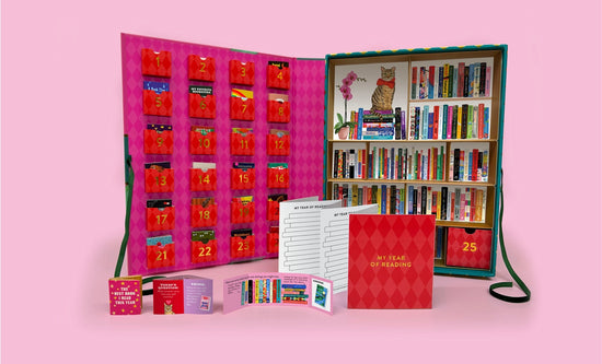 An advent calendar open to show the inside which features 24 pockets filled with tiny books. Some of the books are in front of the calendar.