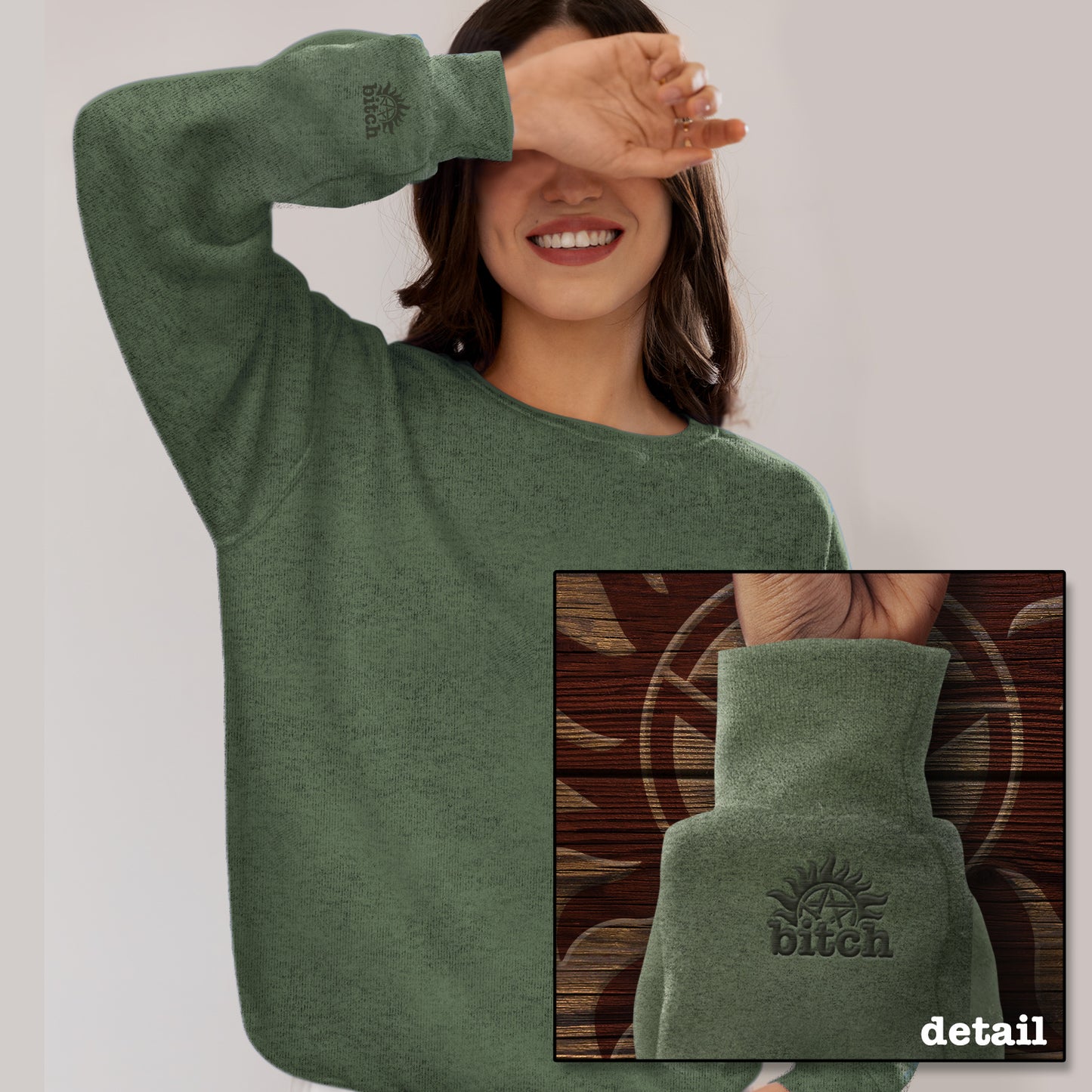 A model wearing a green sweatshirt. An inset image shows the cuff which features an embroidered anti-possession symbol with "bitch" underneath