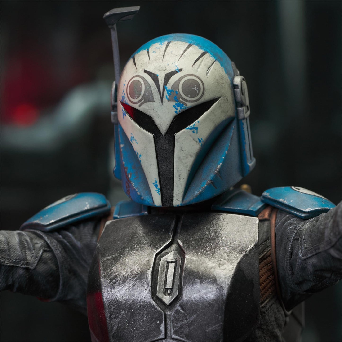 A resin bust depicting Bo-Katan Kryze in her Nite Owl armor, holding blasters in each outstretched hand. In the background is a hangar bay.