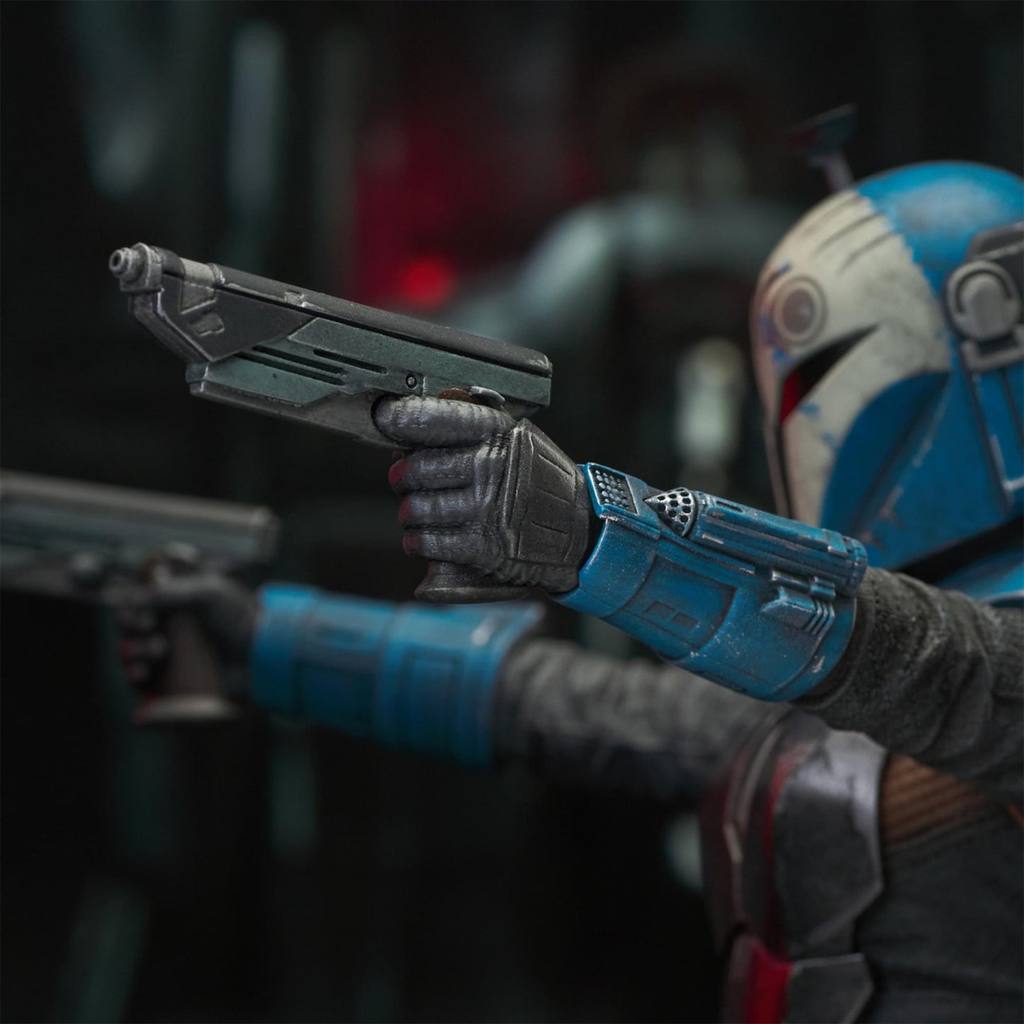 A resin bust depicting Bo-Katan Kryze in her Nite Owl armor, holding blasters in each outstretched hand. In the background is a hangar bay.