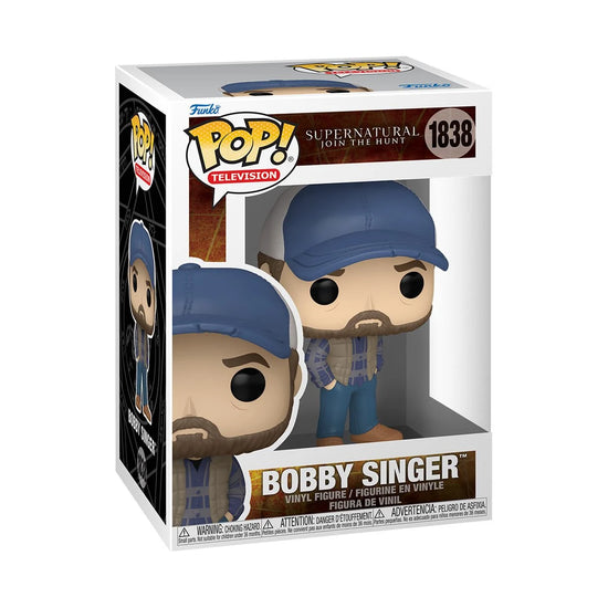 A cardboard box with a transparent front, containing a bobblehead figure depicting the character Dean Winchester, as Michael, wearing a long coat and cap.