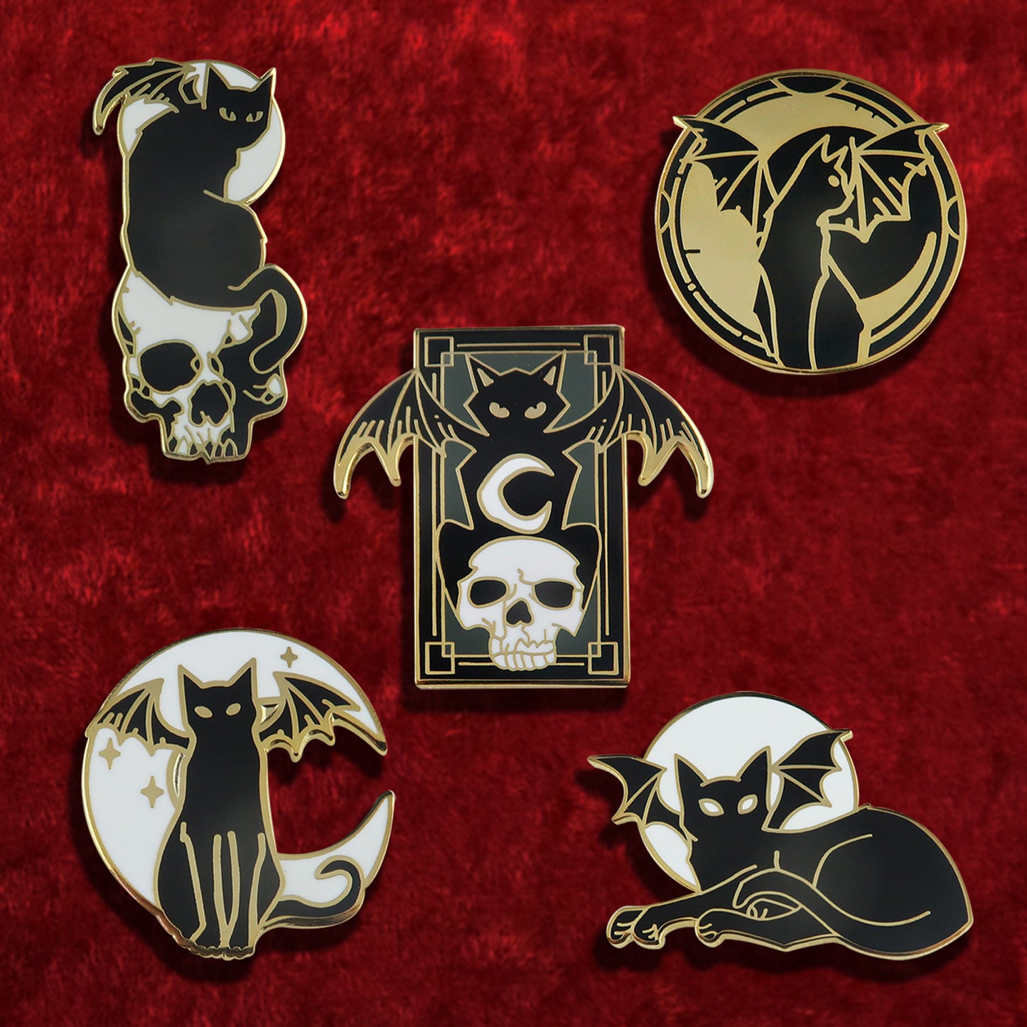 Five black and yellow enamel pins against a red background. Each pin depicts a black cat with bat wings, in various poses.