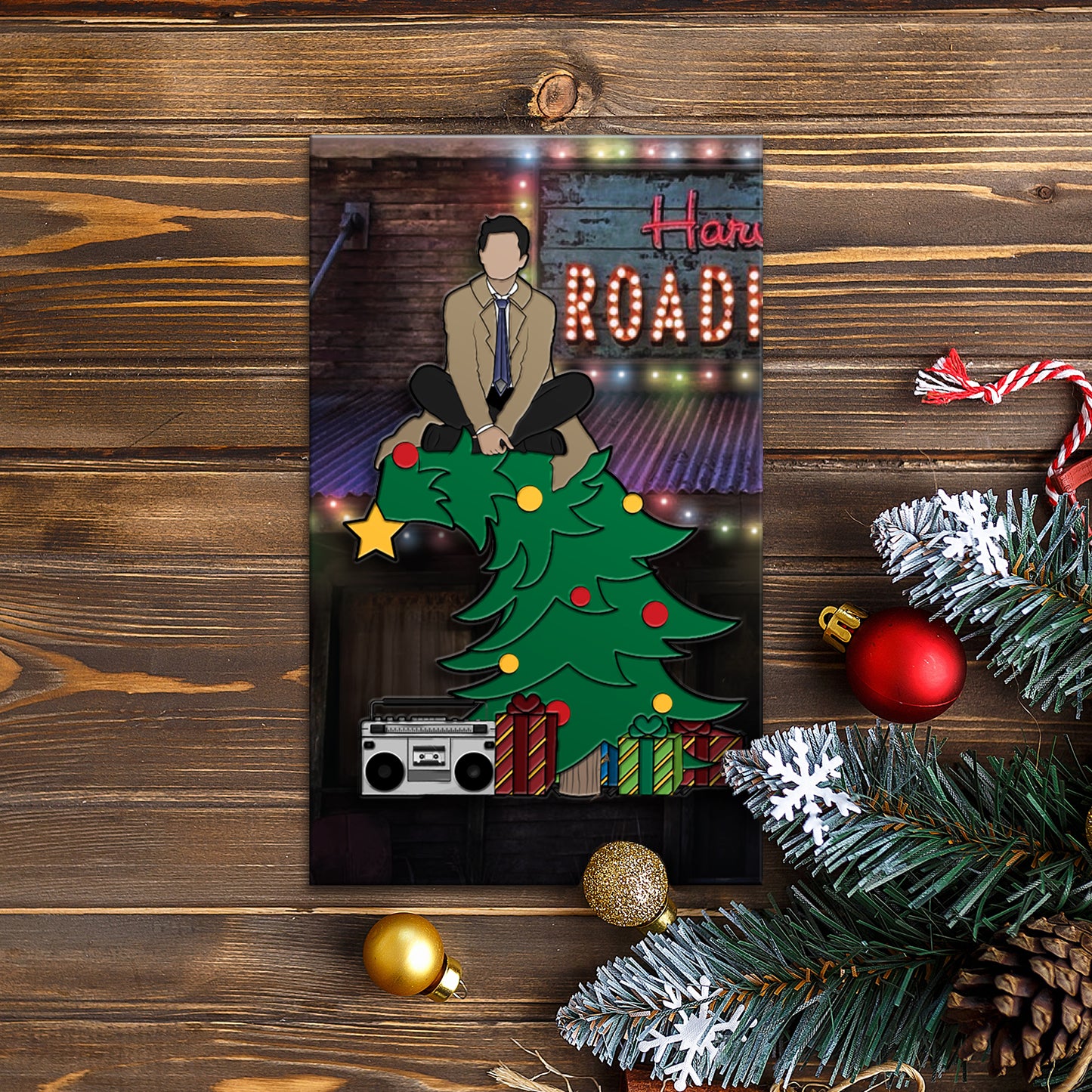 An enamel pin depicting Castiel sitting on  a  Christmas tree