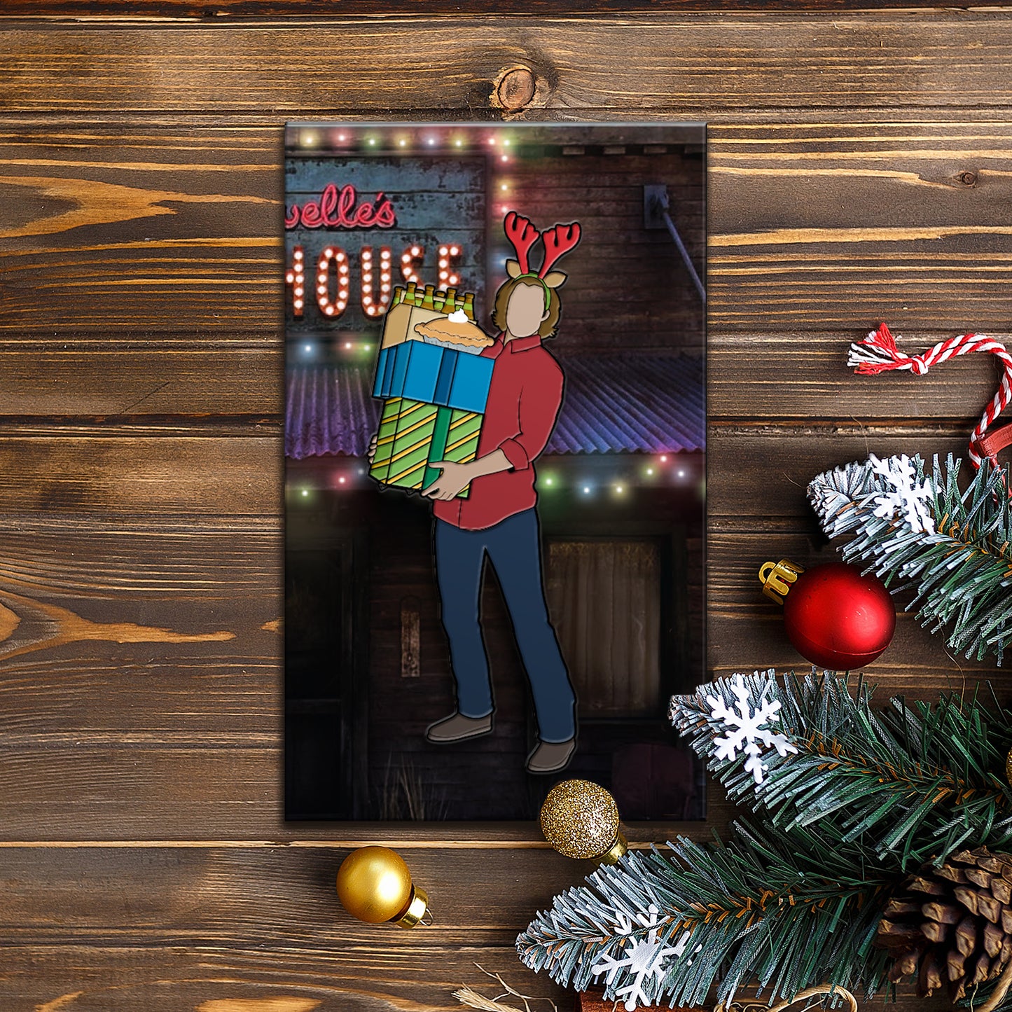 An enamel pin depicting Sam Winchester carrying Christmas gifts, and wearing antlers on his head