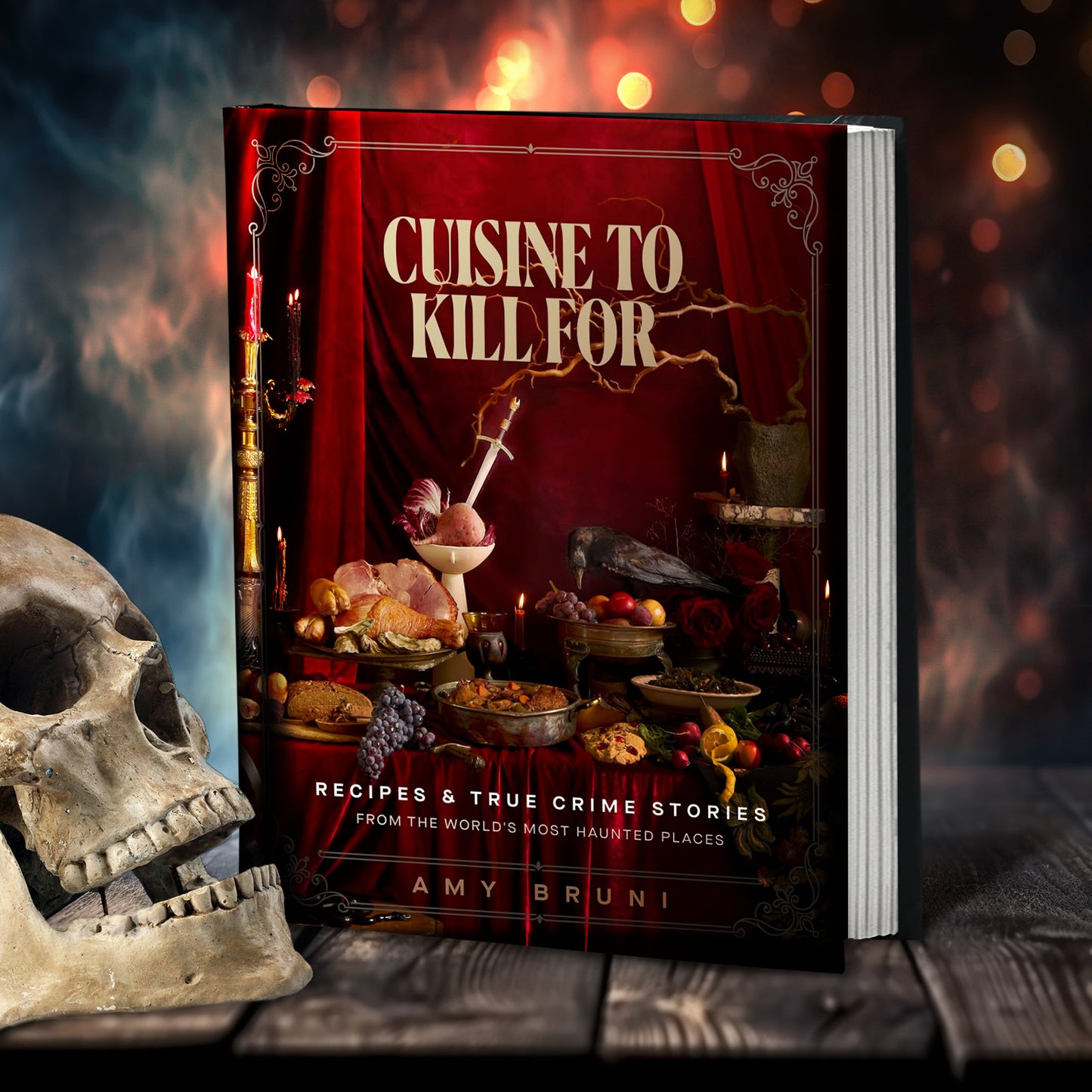 A hardcover recipe book on a wooden table. The cover depicts various recipes from the book on a table, with a dagger stuck in one of them. Text on the cover says "Cuisine to kill for, recipes & true crime stories from the world's most legendary haunted places." Next to the book is a skull, with swirling book and red in the background