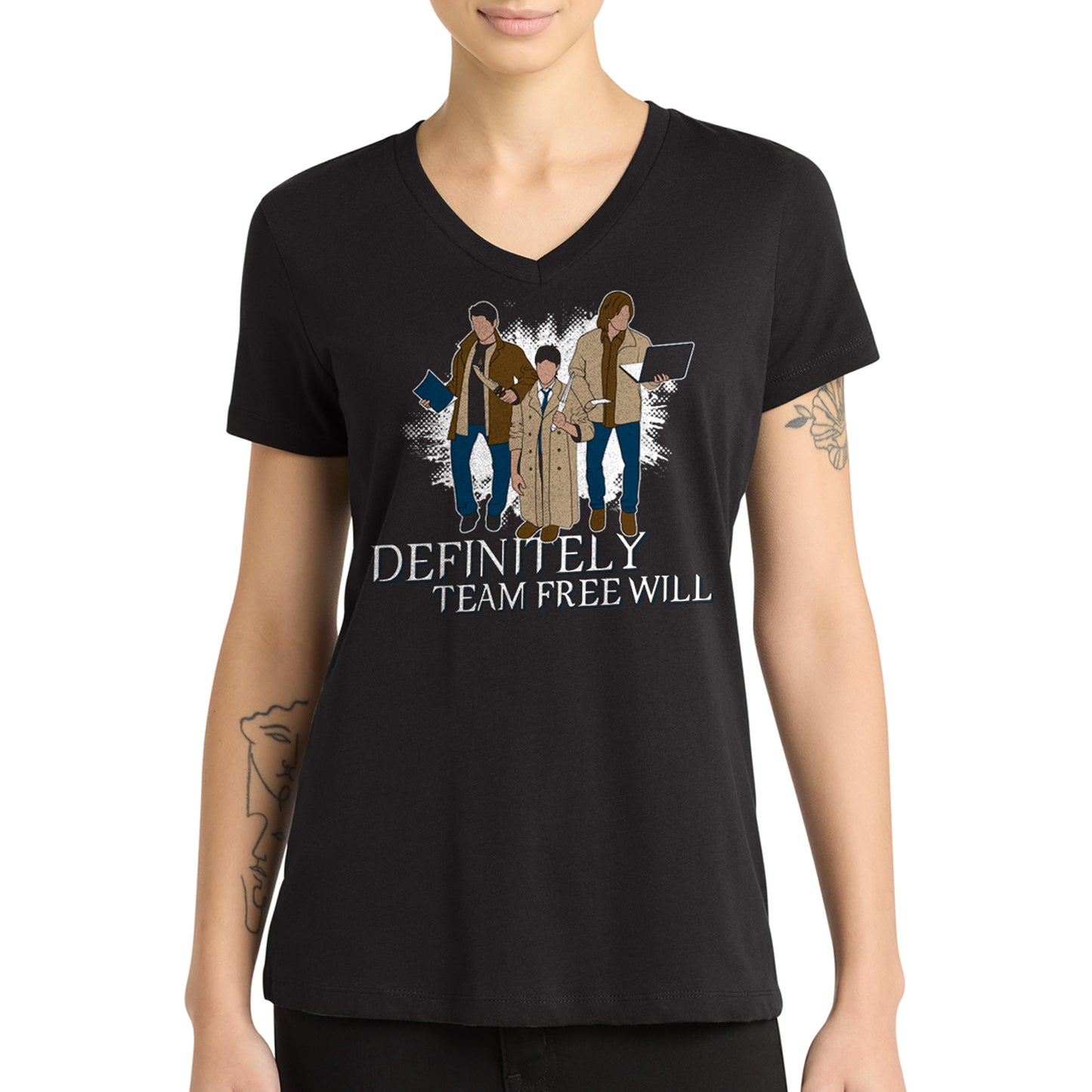 A femodel in a black tee shirt against a white background. On the shirt is the famous behind the scenes picture of Misha, Jared, and Jensen trading their characters's outfits. White text underneath says "Definitely Team Free Will."