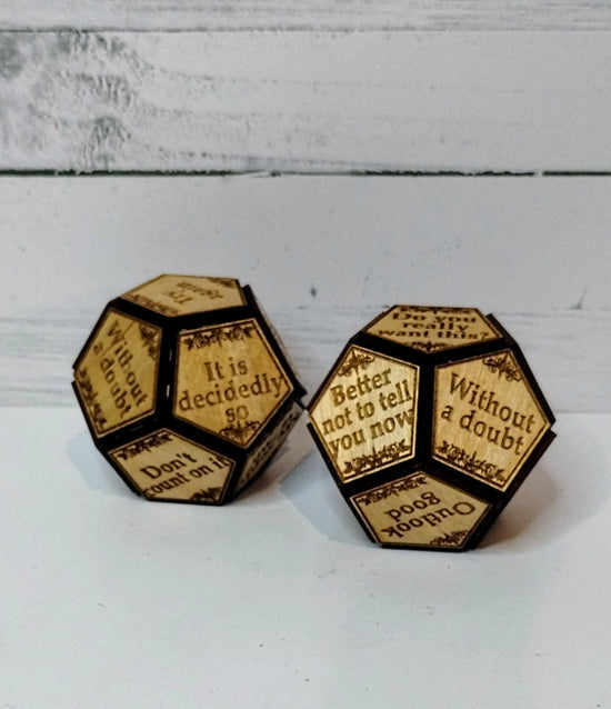 A pair of wooden 12-sided dice, with statements on each side. The statements include don't count on it, outlook good, without a doubt, and other similar sayings.