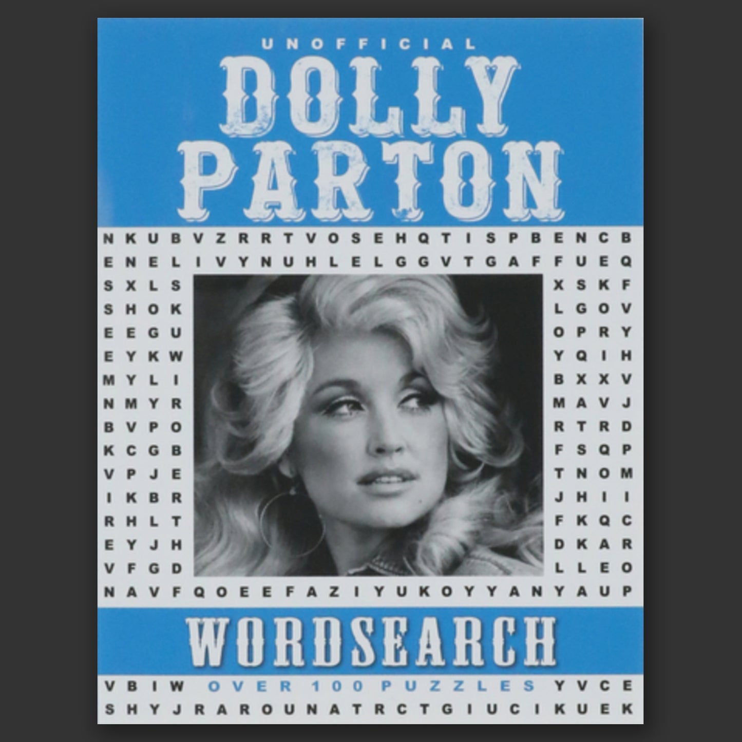 A blue and grey paperback book on a grey background. In the center is a black and white photo of musician Dolly Parton, surrounded by random letters. At the top and bottom are blue banners. White text says "unofficial Dolly Parton Wordsearch."